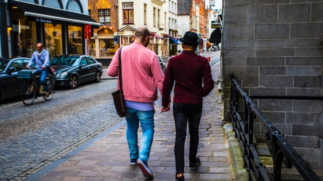 The most LGBTQ friendly travel destinations represented by two men walking down the street holding hands.