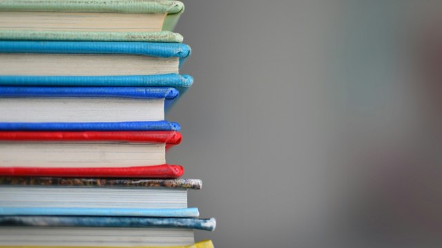 A stack of books to represent six books for learning Spanish.