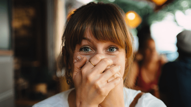 A woman covering her mouth after accidentally using insulting words