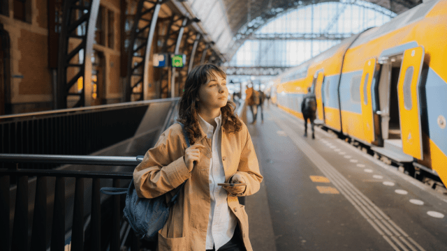 Wanderluster book recommendations represented by a woman in a train station looking thoughtful.