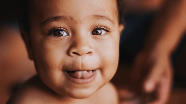 US Baby Names represented by a baby sticking their tongue out to the camera.
