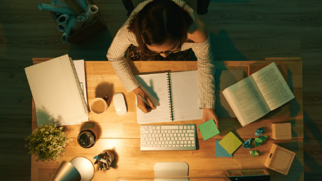 An overhead shot of a woman working at her desk to demonstrate language immersion