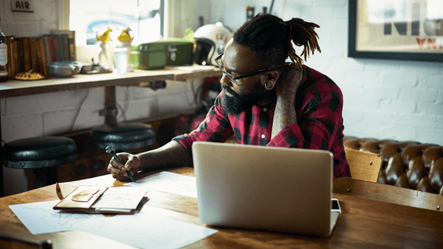 man sitting at his laptop taking notes how to start learning a language