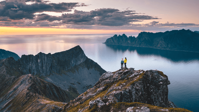 two hikers on a mountain at sunset speaking hybrid languages