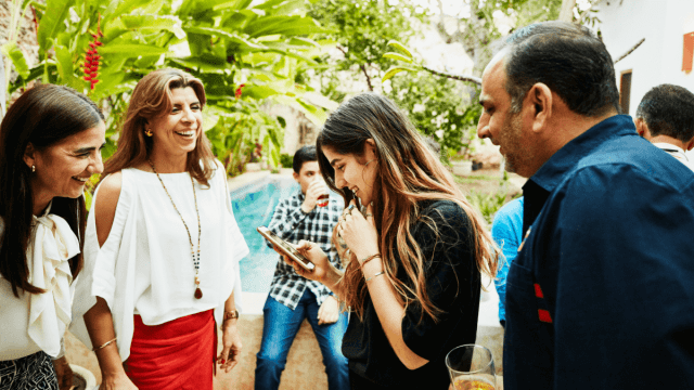 friends laughing in a group outside common spanish verbs