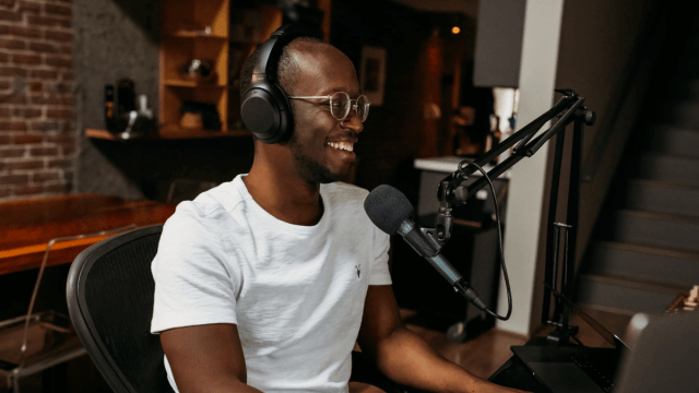 A man in a white t-shirt recording a podcast to exemplify Danish podcasts