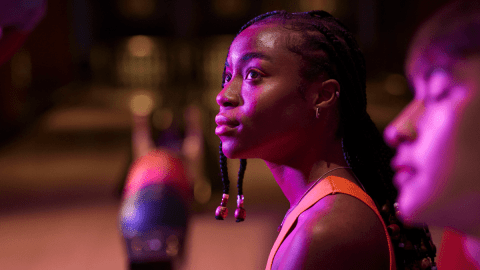 Does Language change your personality by a young woman sitting outside in front of a glowing purple light.