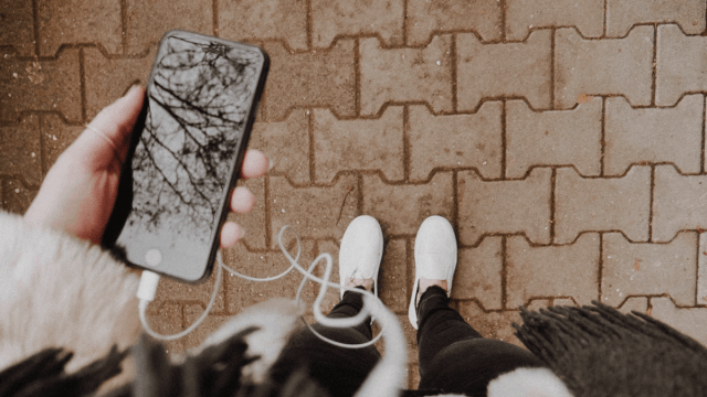 Point of view photo of someone looking down at their phone, listening to Russian podcasts
