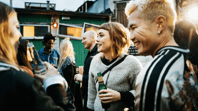 Funny German expressions represented by a group of young people hanging out and drinking at an outdoor Berlin bar.